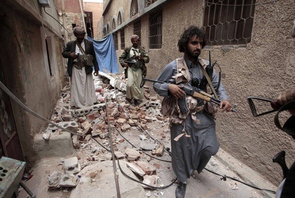 Armed tribesmen loyal to Yemeni tribal leader Sadiq al-Ahmar walk outside his house in Sanaa