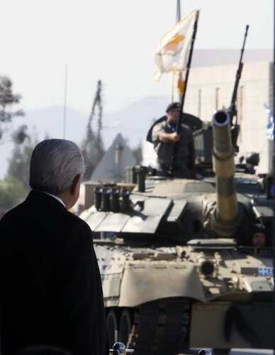 Cypriot President Christofias looks at battle tanks on parade during independence day celebrations in Nicosia