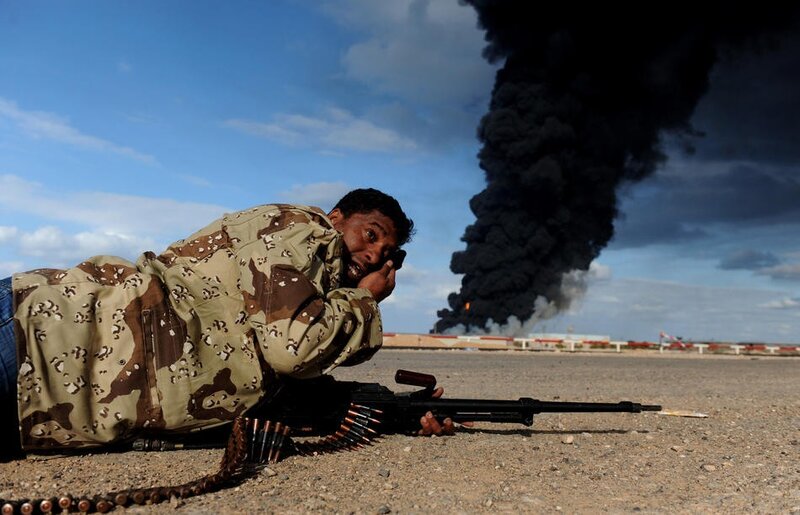 A Libyan rebel fighter lies on the groun
